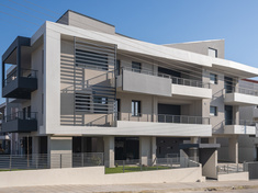 Two storey apartment building with open ground-floor parking area and basement storage